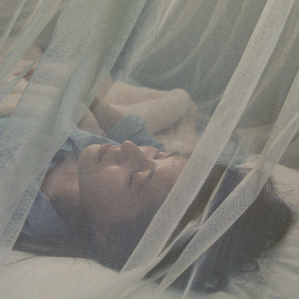 Sleeping under a mosquito net (Photo by Chris Clogg)