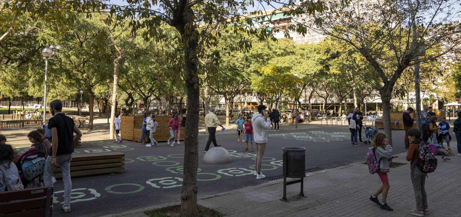 Autor: Àlex Losada / Ajuntament de Barcelona. Famílies i infants a l'entorn de l'Escola Lavínia caminant per la vorera i la zona pacificada davant del centre educatiu