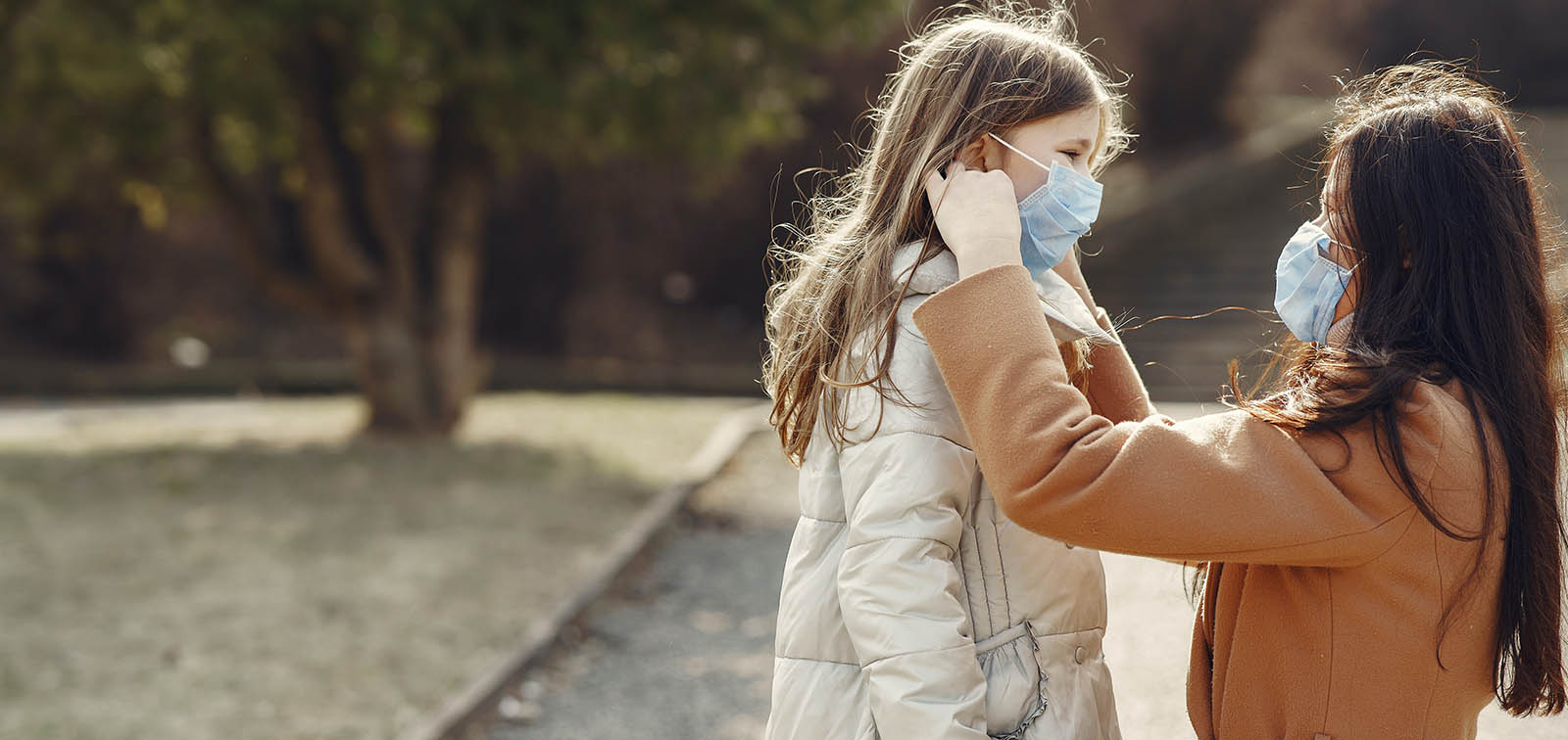 Una mujer pone una mascarilla a su hija