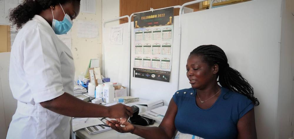 Mujer embarazada africana recibe un tratamiento de manos de una doctora