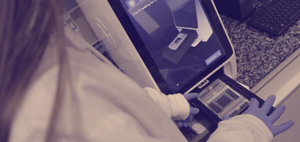 Una investigadora introduce unas muestras en un equipamiento para realizar análisis inmunológico
