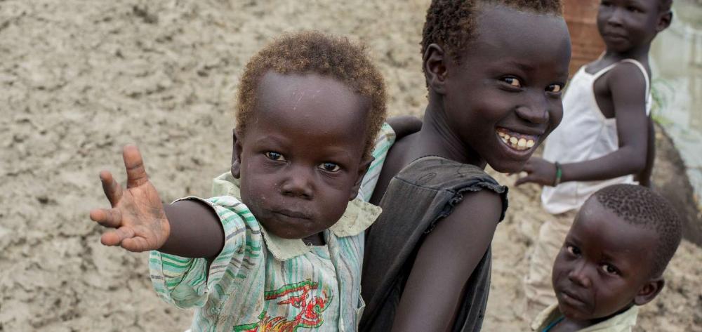 Smiling African baby on his sister's back.