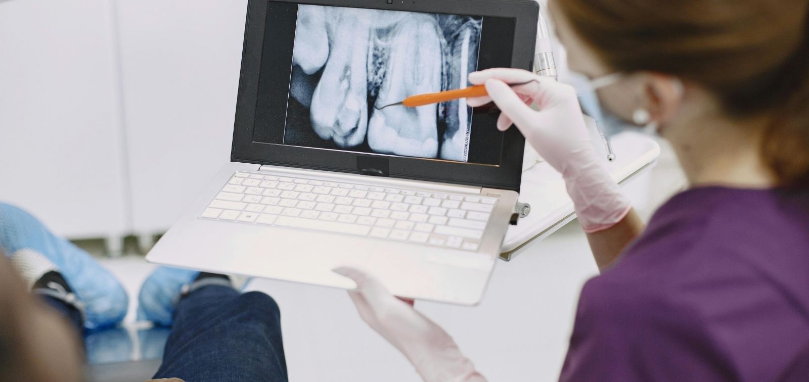 A healthcare worker shows an X-ray to a patient.