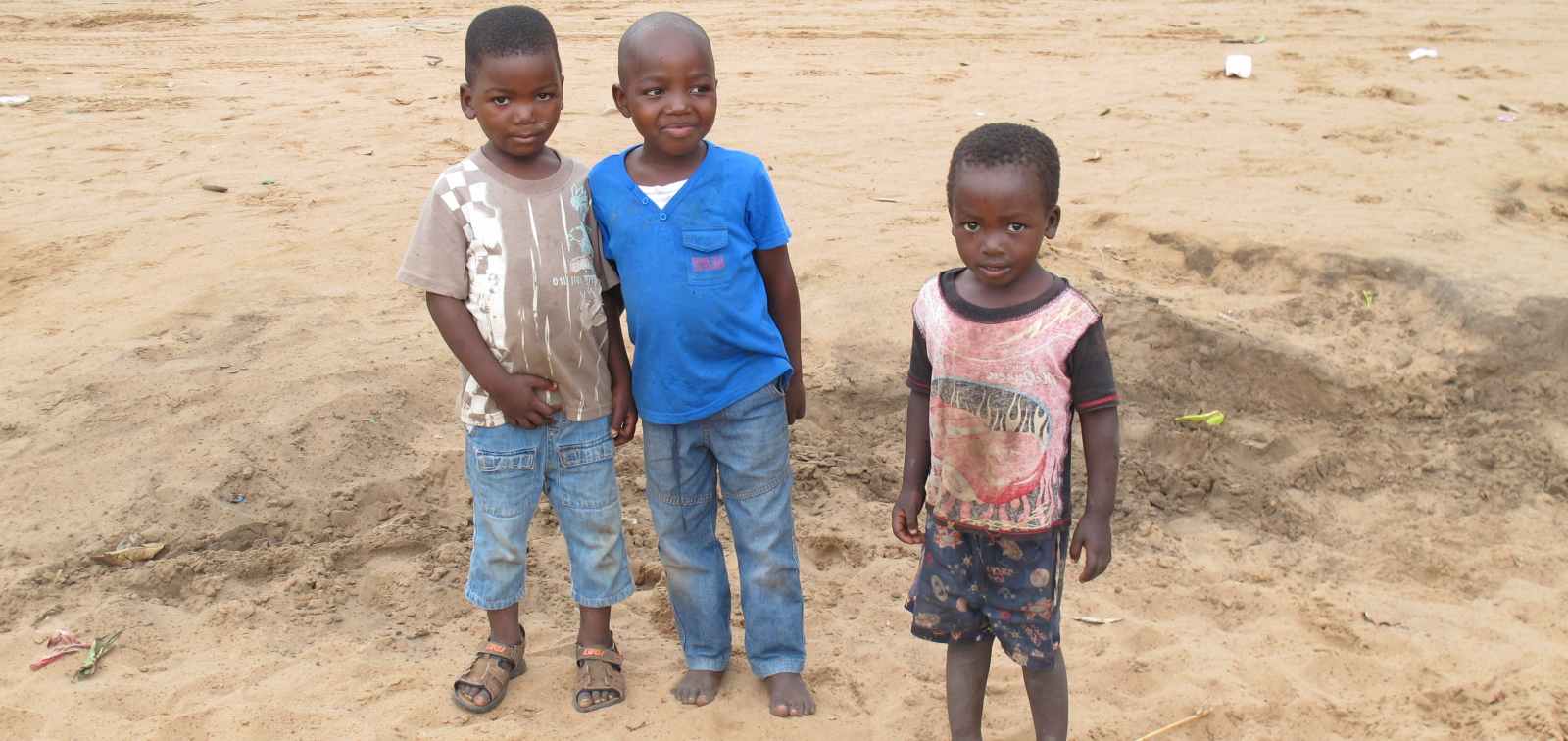 Tres niños africanos en un camino de tierra en Mozambique