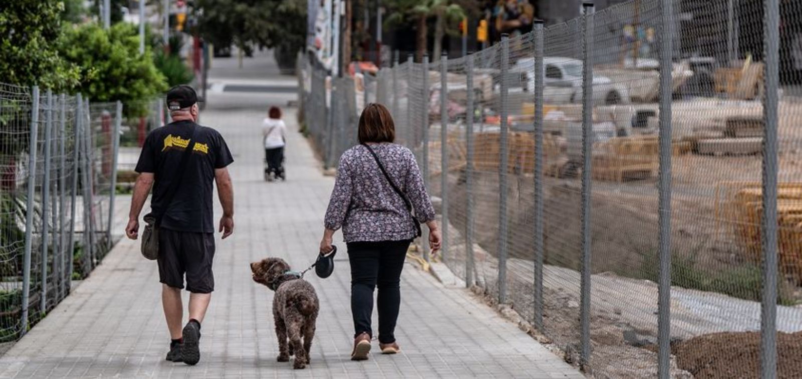 A couple walking their dog along Almogàvers and Zamora streets in Barcelona