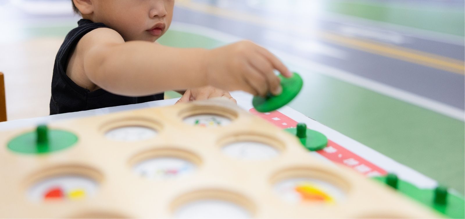 Niño de unos 2 años jugando con piezas de madera.