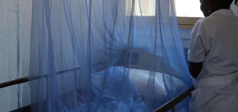 Enfermera preparando una cama de hospital con mosquitera en Manhiça, Mozambique