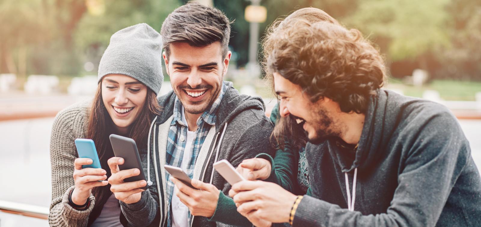 Un grupo de jóvenes consultan sus teléfonos móviles