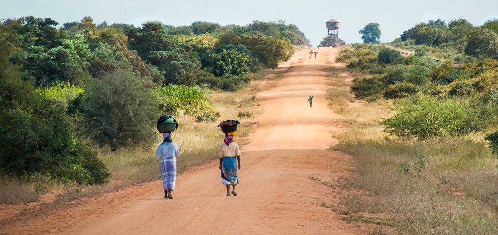 Dones caminant per un camí de sorra cap a Mapai, Moçambic.