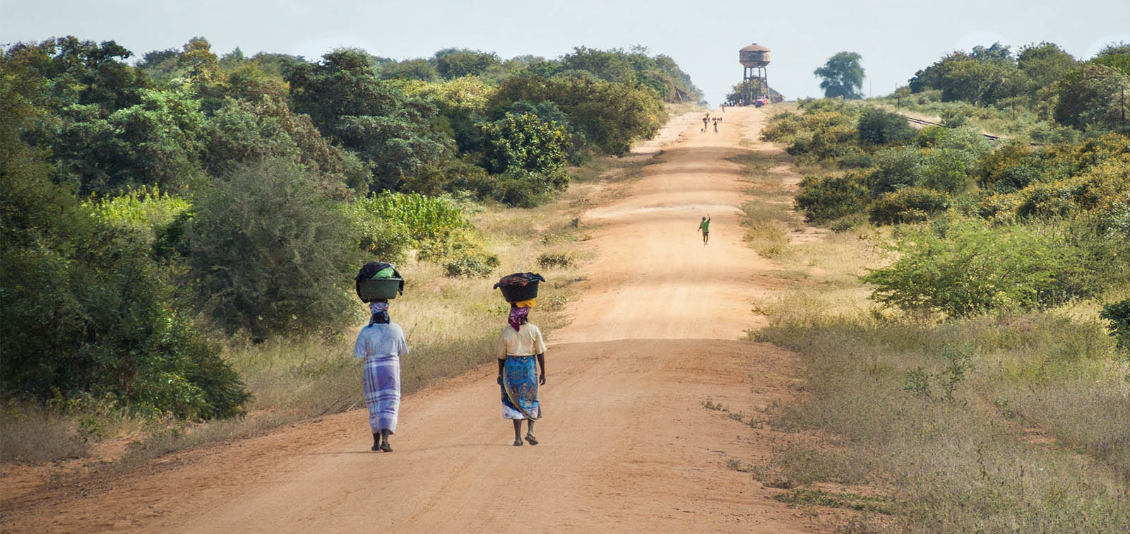 Mujeres andando por una carretera de arena hacia Mapai, Mozambique.