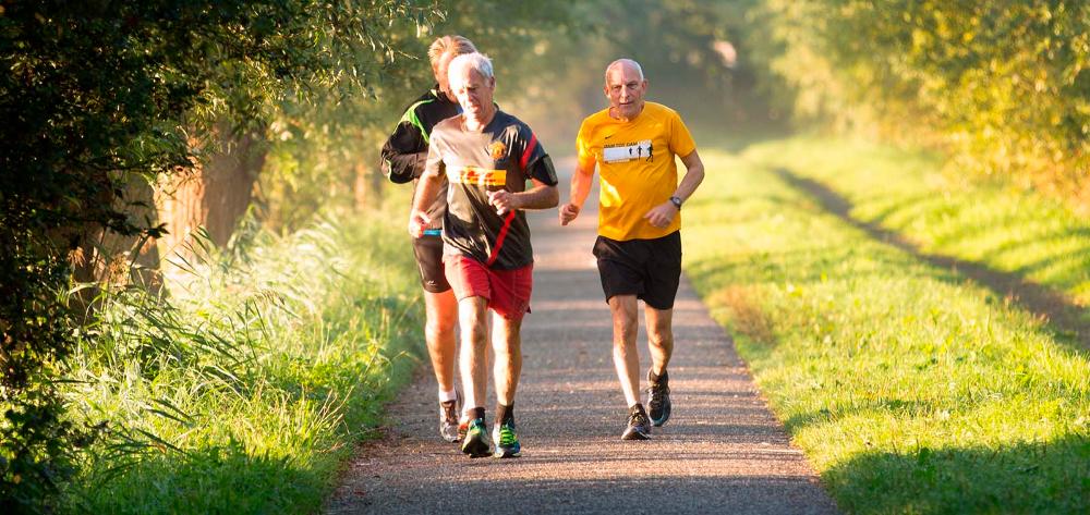 Tres hombres mayores corriendo en el parque